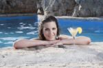 Woman Relaxing  In Swimming Pool With Cocktail Stock Photo