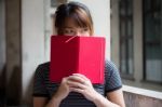 Portrait Of Thai Adult Beautiful Girl Reading Red Book Stock Photo