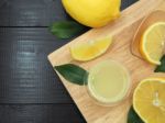 Fresh Lemon Juice In Small Bowl And Lemon Slice On Dark Wood Bac Stock Photo