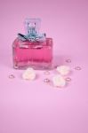 Pink Aromatic Perfume With Pink Pearls With Pink Textile Roses On Pink Background Stock Photo