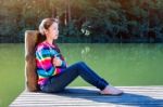 Young Girl Sitting On A Pier Stock Photo