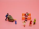 Miniature Santa Claus, A Man With Trolly And Children On Pink Ba Stock Photo