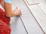 Handyman's Hands Laying Down Laminate Flooring Boards Stock Photo