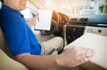 Delivery Man With Cardboard Box Checking Document List In Van An Stock Photo