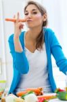 Pretty Young Woman Having Fun With A Carrot In The Kitchen Stock Photo