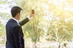 Business Man Using Mobile Phone While Standing On The Balcony In Stock Photo