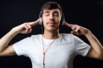 Young Beautiful Man Listening To Music. Isolated On Black Stock Photo