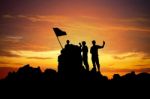 Silhouette Of A Champion On Mountain Peak At Sunset Stock Photo