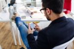 Handsome Young Man Using His Mobile Phone In The Office Stock Photo