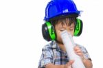 Young Boy Engineer With Blueprint, Wearing Earmuffs And Blue Helmet Stock Photo