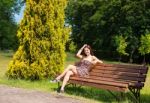 Young Girl Sitting On A Park Bench Stock Photo