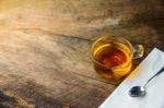 Glass Cup Of Tea And Spoons On Old Wooden Table Stock Photo