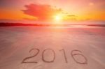 2016 Inscription Written In The Wet Yellow Beach Sand Stock Photo