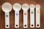 Measuring Spoons In Varying Sizes On Wooden Background Stock Photo