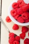 Bunch Of Fresh Raspberry On A Bowl And White Table Stock Photo