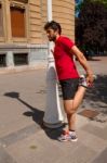 Urban Athlete Doing Stretching Next To A Lamppost Stock Photo