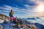 Young Woman Hiker Taking Photo With Smartphone On Mountains Peak In Winter Stock Photo