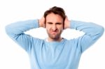 Irritated Man Blocking His Ears Stock Photo