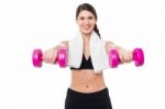 Trainer Holding Dumbbells In Her Outstretched Arms Stock Photo