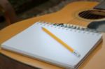 Yellow Acoustic Guitar On Wooden Table Stock Photo