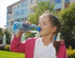 Girl Drinks Water From A Bottle Stock Photo