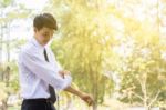 A Young Businessman Is Folding A White Sleeve On His Balcony Stock Photo