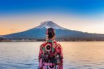 Asian Woman Wearing Japanese Traditional Kimono At Fuji Mountain. Sunset At Kawaguchiko Lake In Japan Stock Photo