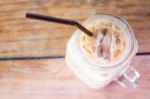 Glass Of Iced Coffee On Wooden Table With Vintage Filter Style Stock Photo