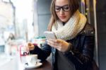 Beautiful Girl Using Her Mobile Phone In Cafe Stock Photo