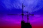 Dark Twilight And Silhouette Construction With Crane On Top Building Stock Photo