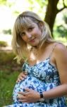 Young Beautiful Pregnant Woman In City Park Stock Photo