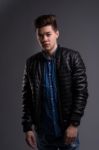 Casual Young Man In Black Leather Jacket And Denim Jeans Stock Photo