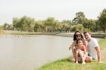 Family Sitting Near The Lake Stock Photo