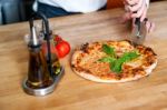 Baker Cutting Pizza At Kitchen Stock Photo