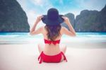 Young Woman In Red Bikini Sitting On The Beach Stock Photo