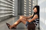 Asian Woman Sitting On Corridor Floor Stock Photo