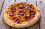 Delicious Baked Salami Pizza Served On Rustic Wooden Table Stock Photo