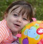 Infant Leaning On Her Ball Stock Photo