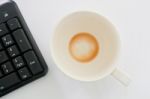 Empty Cup And Computer Keyboard Stock Photo