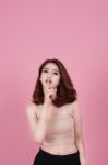 Beautiful Young Woman Pointing Finger To Her Lips Over Pink Past Stock Photo