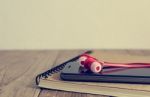 Earphones, Smart Phone And Notepad Are On Table Stock Photo