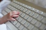 New Born Baby's Hand Using Keyboard Stock Photo