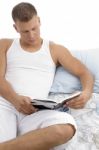 Man Lying On Bed And Reading Book Stock Photo