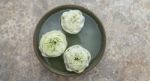 White Lotus Floating In The Green Bowl Stock Photo