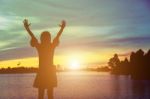 Silhouette Of Woman Praying Over Beautiful Sky Background Stock Photo