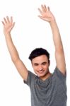 Cheerful Young Guy Raising His Arms Stock Photo