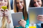 Friends Surfing The Net With Smartphones And Digital Tablets Stock Photo