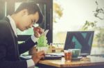 Business Man Sitting On A Calculator To Figure Out In A Coffee S Stock Photo