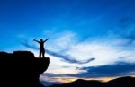 Silhouette Of A Man On The Rock At Sunset Stock Photo