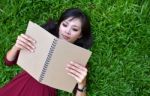 Woman Lying On Green Grass With  Book Stock Photo